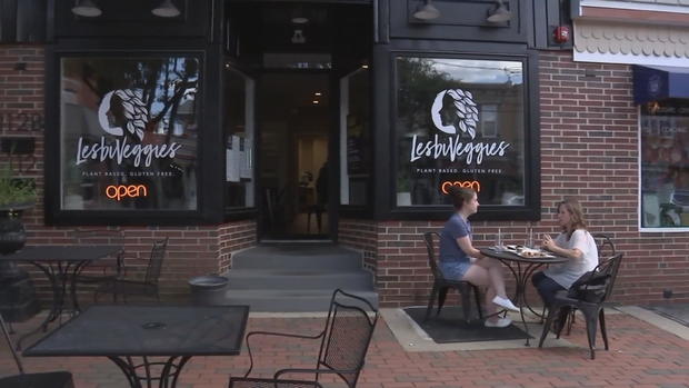 Two people eat at a table outside of LesbiVeggies in Audubon 