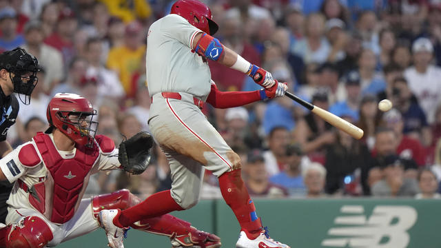 Kyler Schwarber hits a three-run double in front of Boston Red Sox catcher Connor Wong during the fourth inning of a baseball game in Boston 