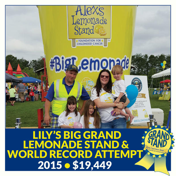 The Adkins family in front of a huge cup of lemonade. The text says Lily's big grand lemonade stand and world record attempt, 2015, $19,449 