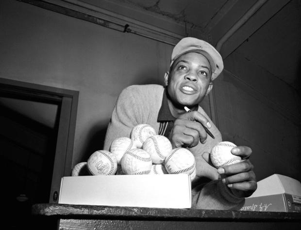 Willie Mays autographing baseballs in 1956 