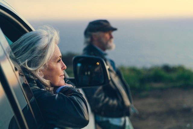 Mature woman sitting in car during sunset 