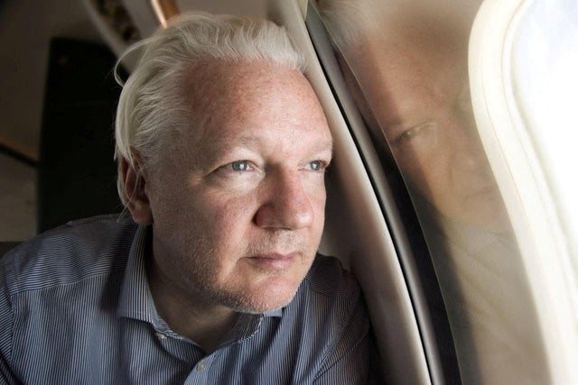 WikiLeaks founder Julian Assange looks out a plane's window 