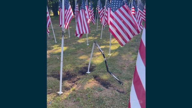 A damaged flagpole is seen among several American flags in a patriotic display in Audubon 