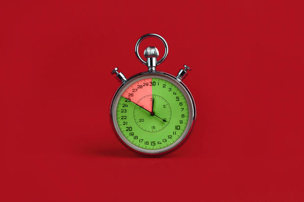 stopwatch with colorful segments on red background. Interest-free period concept 