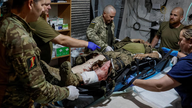 Medics help a wounded Ukrainian serviceman inside a medical stabilisation point near the town of Chasiv Yar, in Donetsk region 