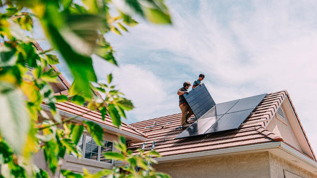 Young Homeowners installing Solar Panels on a Suburban Western USA Home 