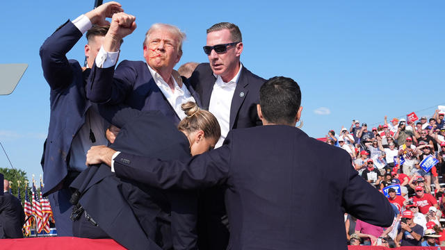 Former President Donald Trump surrounded by Secret Service agents at campaign rally 