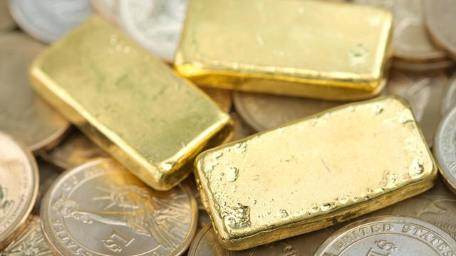 Gold bar over dollar coins 