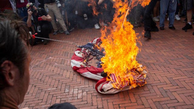 Pro-Palestinian demonstrators burn a U.S. flag at Union Station in Washington, D.C., on Wednesday, July 25, 2024. 