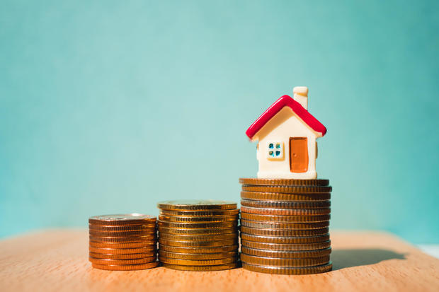 Miniature colorful house on stack coins 