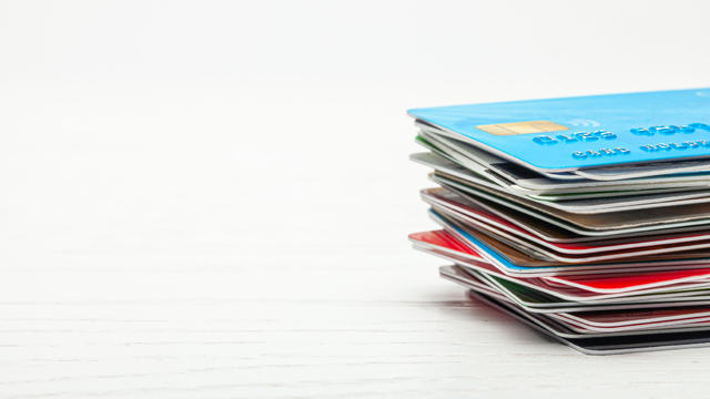 Stack of credit cards isolated on white wooden background 