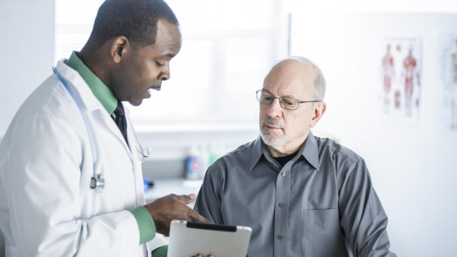 African American doctor talking to patient in office 