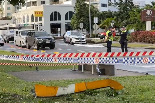 This frame grab taken from video footage provided by Australian Broadcasting Corporation (ABC) via AFPTV shows a piece of the helicopter lying on a roadside after a helicopter crashed into the roof of a Hilton hotel in Cairns on August 12, 2024, killing the pilot and igniting a blaze on the building's roof