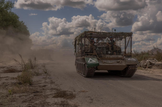 Ukrainian servicemen drive an armored military vehicle past a destroyed border crossing point with Russia, in the Sumy region, on Aug. 14, 2024. 