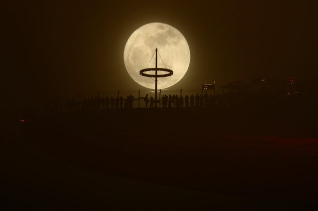 Uma lua de esturjão, a primeira Superlua do ano, surge ao lado do hotel Marina Bay Sands, em Cingapura