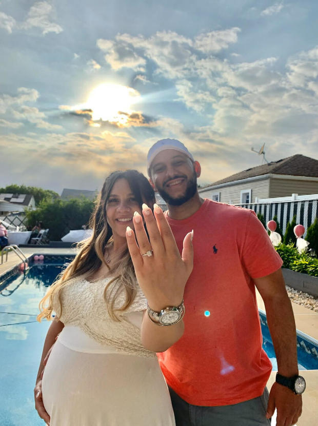 Alexis poses for a photo with her fiance, holding up a hand to show off her engagement ring 