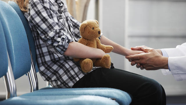 Doctor holding young girls hand 