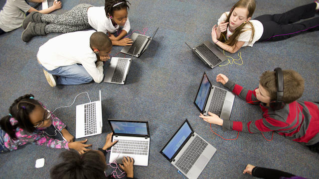 Fourth grade students work on laptops in class. 