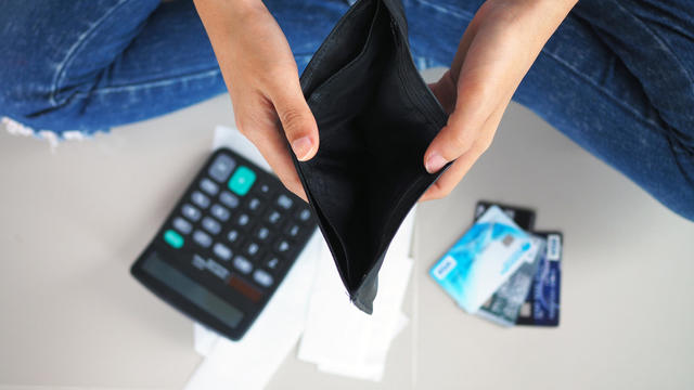 Woman's hands open empty purse. Poverty, debt and bankruptcy in the payment of bills and credit cards. Broke concept 