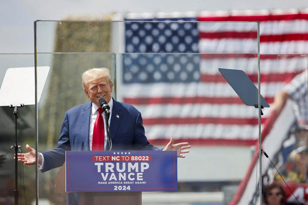 Former President Donald Trump speaks from a bulletproof glass housing during a campaign rally in Asheboro, North Carolina, on Aug. 21, 2024. 