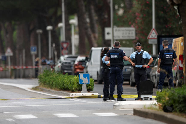 French police stand guard after cars were set on fire in front of the city's synagogue, in La Grande-Motte 