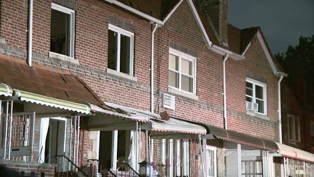 A row of homes in Brooklyn. One home's windows appear to be blown out. 