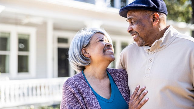Portrait of senior couple in front of suburban home
