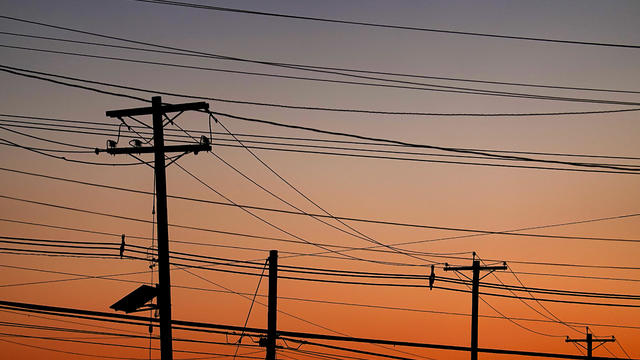 Many Power Lines in front of colorful Sky 