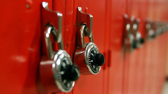 Combination locks on a row of red high school lockers 