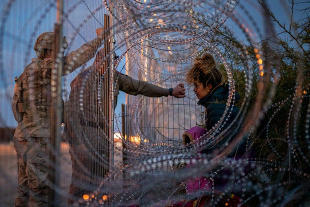 Eliana, 22, a migrant from Venezuela, holds her daughter Crismarlees, 3, while being denied entry after attempting to cross through concertina wire on the U.S. side of the Rio Grande on March 26, 2024, in El Paso, Texas.