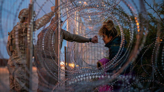 Eliana, 22, a migrant from Venezuela, holds her daughter Crismarlees, 3, while being denied entry after attempting to cross through concertina wire on the U.S. side of the Rio Grande on March 26, 2024, in El Paso, Texas. 