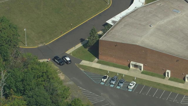 An overhead shot showing two police cars blocking a driveway at Wissahickon High School 