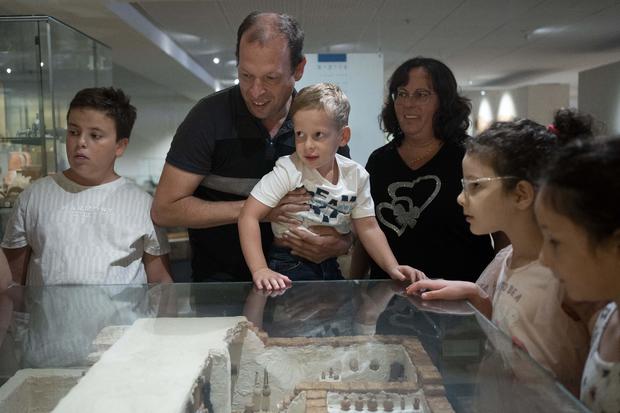 Ariel Heller, 4, center, and his parents Anna, right, and Alex, center left, take part in a special tour after the child accidentally broke an ancient jar at the Hecht Museum in Haifa, Israel