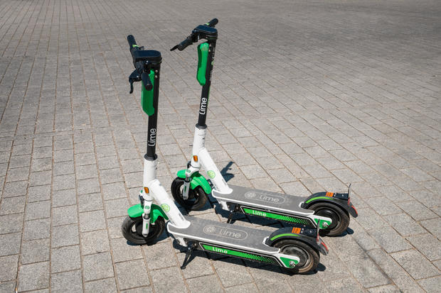 Electric scooter , escooter or e-scooter of the ride sharing company LIME on sidewalk 