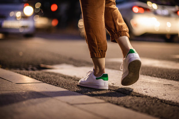 Close up human legs walking on the crosswalk 