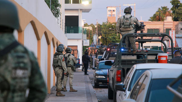 Cartel gunmen are seen outside during clashes with federal forces following the detention of Ovidio Guzman, son of drug kingpin Joaquin 