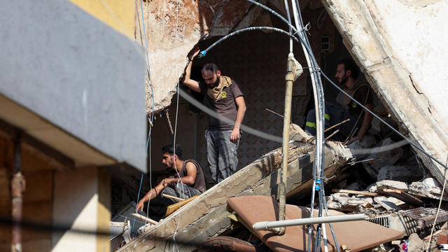 People gather near the site of an Israeli strike in Beirut's southern suburbs 