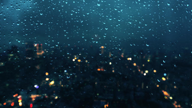 Raindrops on the window with cityscape at night 