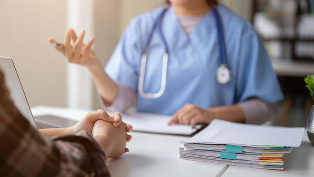 Close-up hand image of a serious patient having a medical consultation with a doctor 