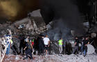 People inspect damage at the site of an Israeli strike in Beirut 