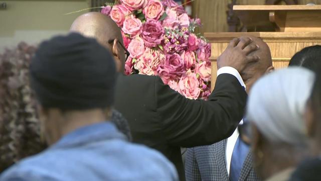 A faith leader places a hand on Mayor Eric Adams' head. 