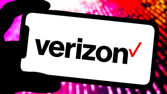 In this photo illustration, a Verizon logo is displayed on 