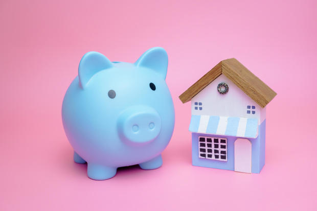 piggy bank and miniature house, concept of saving money to buy a house. 