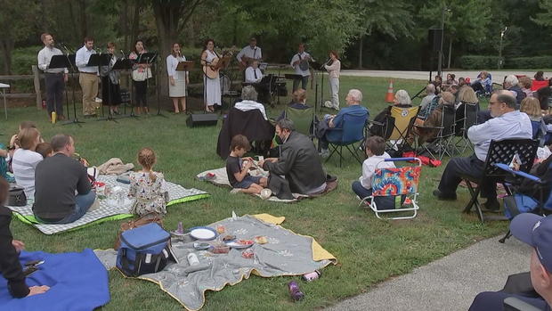 People sit on blankets and lawn chairs during the outdoor service 