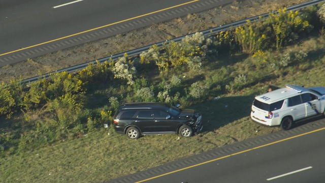 A car is seen after a crash on the side of the road, a Philly police car is nearby 