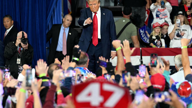 Donald Trump points to the crowd of supporters during a rally 