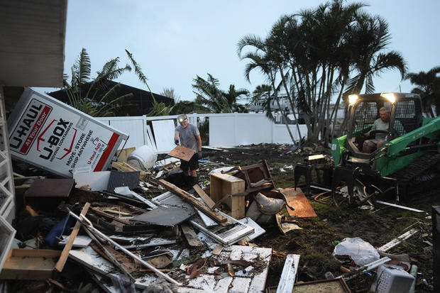 Business City News Homeowner Robert Turick, 68, left, and storm waste removal contractor Sven Barnes work to clear debris that storm surge from Hurricane Milton swept from other properties into Turick's canal-facing backyard, in Englewood, Florida, Oct. 11, 2024. 