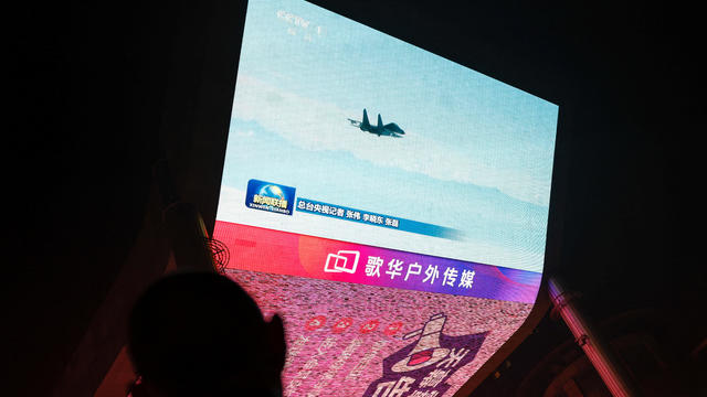 Screen shows news footage of military drills conducted in areas around the island of Taiwan by the Eastern Theatre Command of the Chinese PLA, in Beijing 