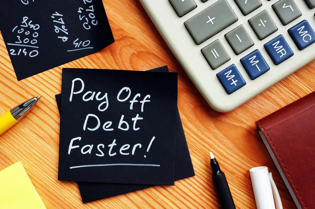 Pay off debt faster handwritten memo and calculator. 