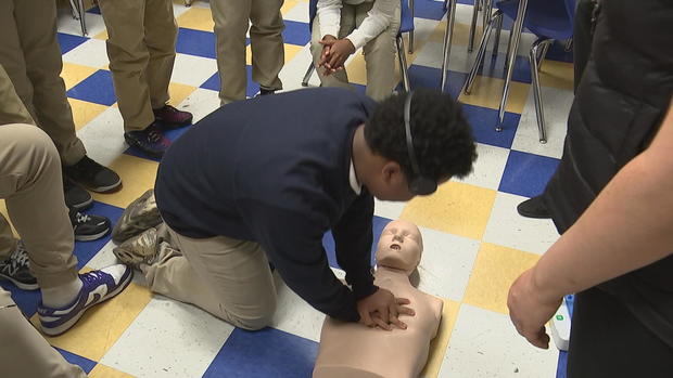 A student does chest compressions on a dummy 